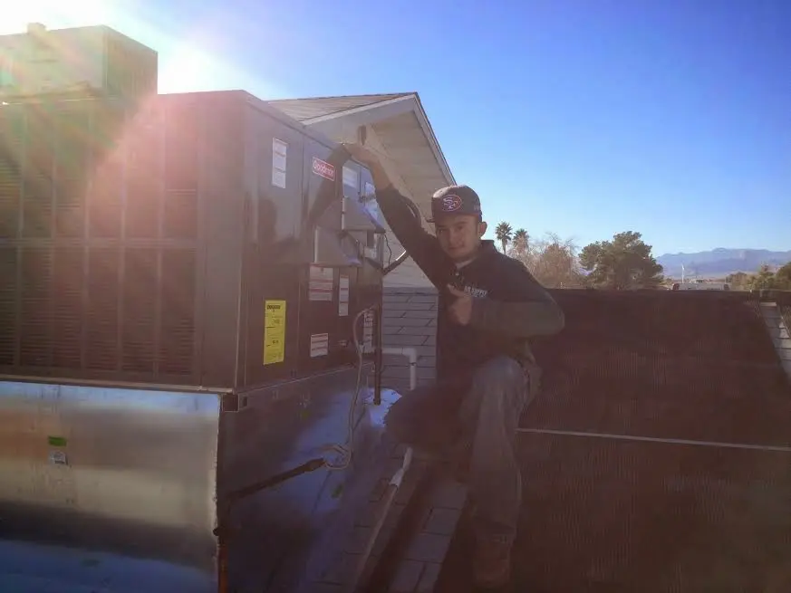 HVAC technician performing AC Tune-Up on a rooftop unit in Crozet